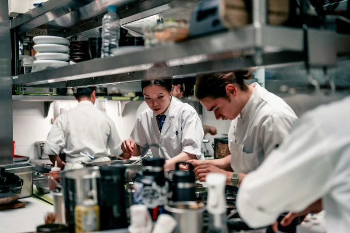 A group of chefs in a kitchen preparing food